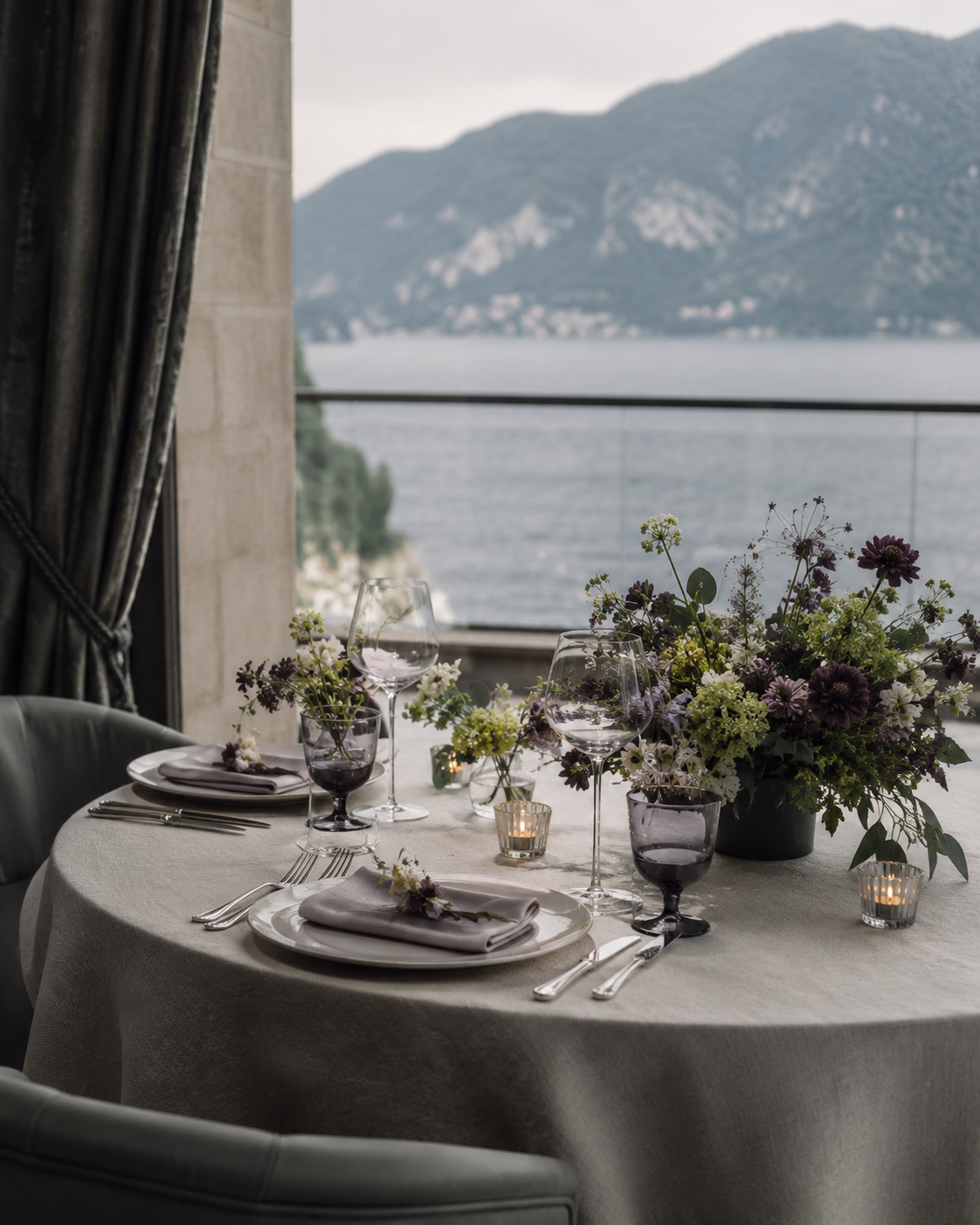 Table dressée face au lac, verres et bouquet de fleurs sauvages